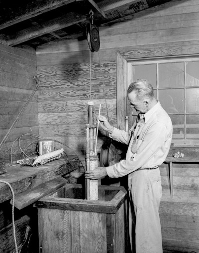 Scripps scientist Claude Palmer with seawater sample at Scripps Pier circa 1950