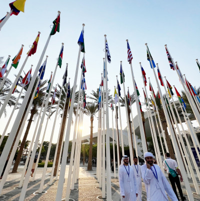 COP28 attendees pass beneath national flags in Dubai's Expo City