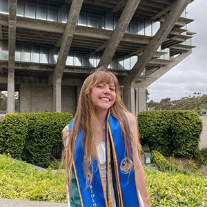 A graduate in front of a library