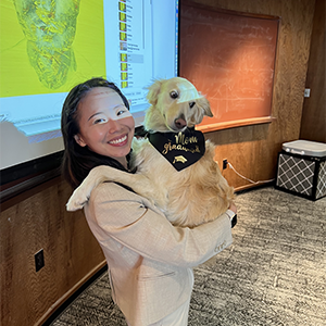 A smiling grad student holds her dog