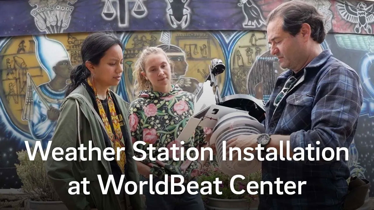 Scientist shows off weather instrumentation to visitors at WorldBeat Center.