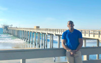 A man stands near a pier