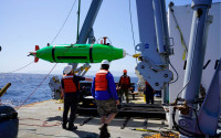 Crew members launch an AUV off a research vessel