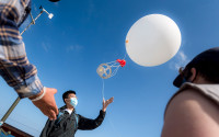 Students watch as a weather balloon is launched for an atmospheric sciences class.