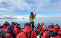 A researcher leads a group of citizen scientists in Antarctica.