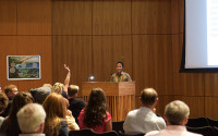 A person presents a lecture at a podium