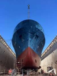 Red and blue research vessel sitting in drydock