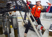 Female scientist celebrating on board a ship. Photo by Melissa Miller.