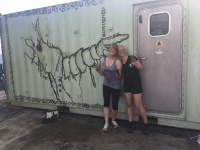 April Stabbins and Lily Simons with unicorn shrimp mural