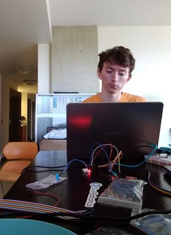 A young man works at his laptop.