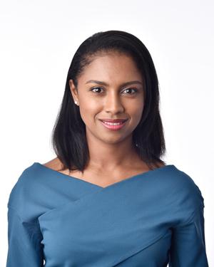 A professional headshot of a woman wearing a blue top