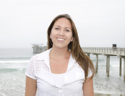 Portrait of a woman standing near a pier and the ocean