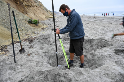 Adam Young buries sensors to collect data on erosive effects of waves on cliffs.