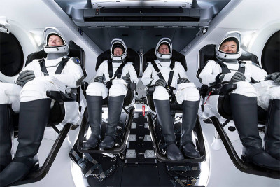 Four astronauts inside a space vehicle