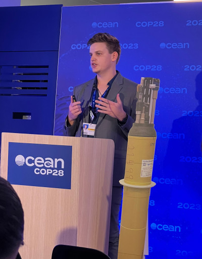 Scripps Oceanography student Mitchell Chandler addresses an audience during COP28 in Dubai, UAE.