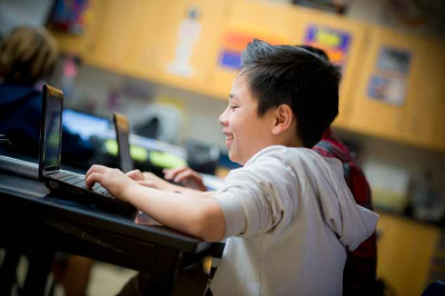 A young student works on a computer