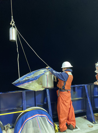 Grace Cawley deploying a net to catch zooplankton in the California Current aboard the R/V Sally Ride.