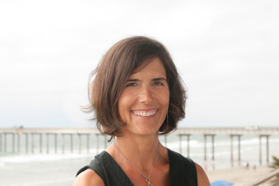 Portrait of a smiling woman with a research pier in the background