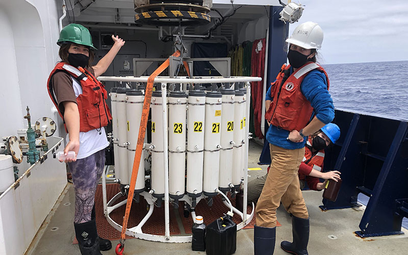 From left, Scripps Oceanography technician Kelsey Vogel, Scripps student Anne Schulberg, and University of San Diego student Grace Cawley with a CTD rosette.