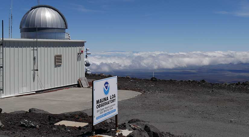 Mauna Loa observatory on volcanic peak with clouds