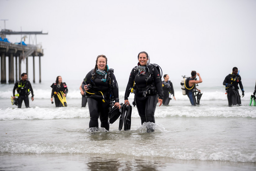 Scripps student divers walking out of the surf.