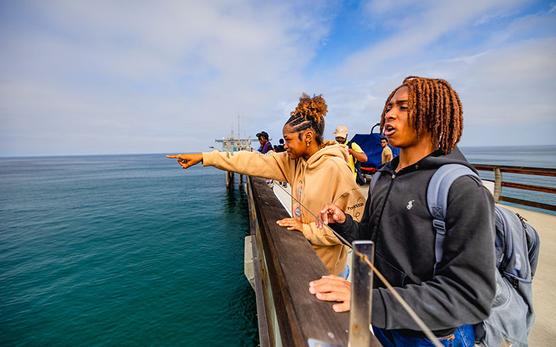 Students overlooking the ocean on Scripps Pier. 