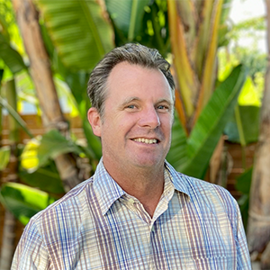 Portrait of a smiling man outdoors near a banana plant