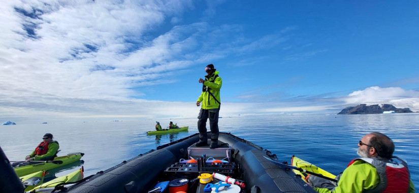 A researcher and citizen scientists on a small boat in Antarctica.