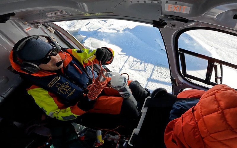 A researcher in a helicopter flying over Antarctica