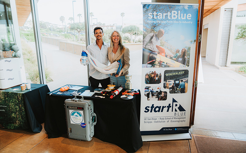 Scripps PhD candidate and co-founder Allison Cusick and Scripps PhD student Christian Johnson pose at their booth on Demo Day