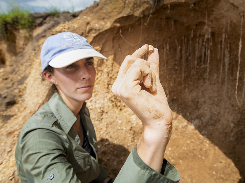 Paula Ezcurra examines a fossil specimen of an unidentified gastropod
