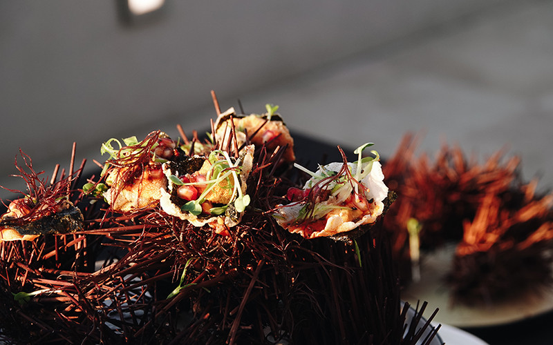 Chef Marcus Twilegar’s seaweed chicharrones with uni, pomegranate, finger lime and pistachio, served on an urchin shell and topped with ogo.  