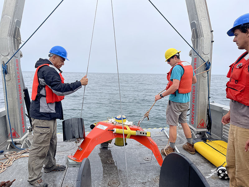 MOD scientists and engineers recover the bottom lander supplied by Scripps oceanographer Geno Pawlak (shown on the left), a co-PI on the experiment. Photo: Sara Goheen